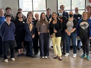 Image of 25 hackathon attendees smiling and standing in a conference room